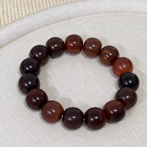 Oversized dark brown 18–19mm barrel-shaped Bodhi bracelet laid flat on light linen.