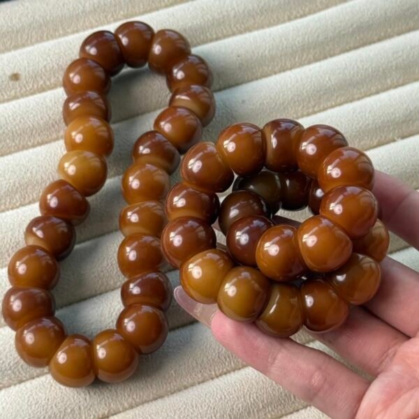 Close-up of glossy caramel-brown garlic-clove-shaped Bodhi beads in the CARAMEL CLOVE 16mm bracelet